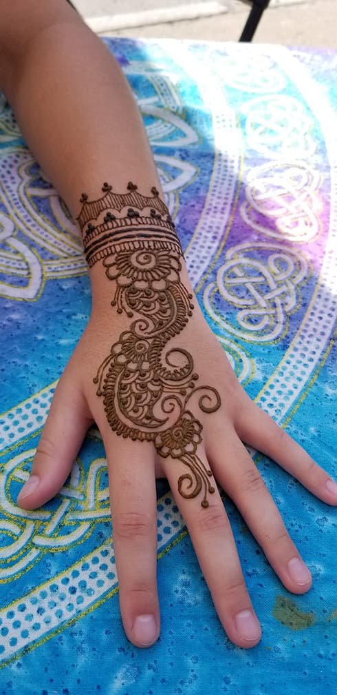 Fine-line henna pattern on a guest at an event